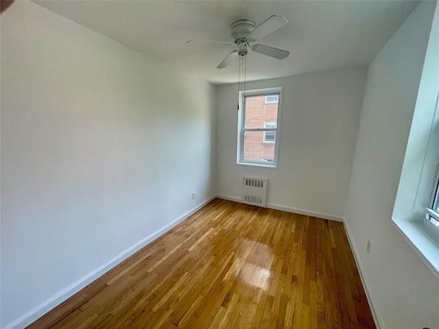 14340 41st Ave Unit 2G, Flushing, NY 11355 - unfurnished room featuring radiator, baseboards, light wood finished floors, and ceiling fan