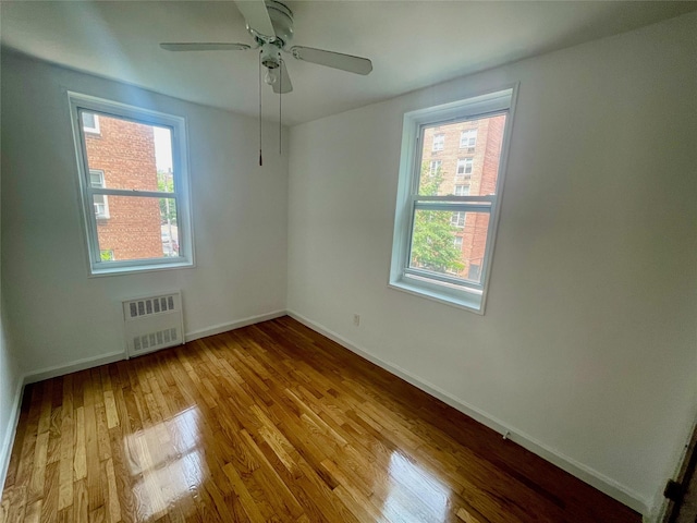 14340 41st Ave Unit 2G, Flushing, NY 11355 - spare room featuring radiator, wood finished floors, baseboards, and a ceiling fan