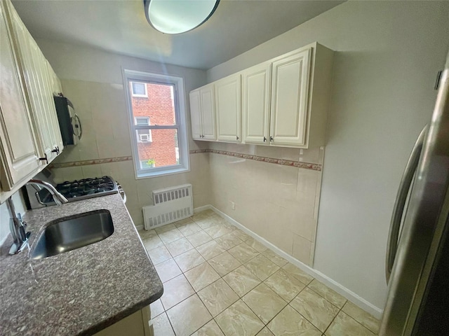 14340 41st Ave Unit 2G, Flushing, NY 11355 - kitchen with radiator heating unit, a sink, range with gas stovetop, dark stone countertops, and baseboards