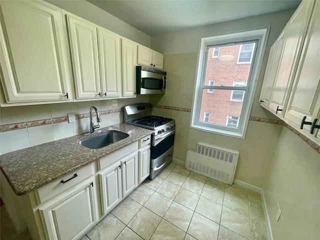 14340 41st Ave Unit 2G, Flushing, NY 11355 - kitchen with appliances with stainless steel finishes, a sink, radiator, dark stone countertops, and white cabinets