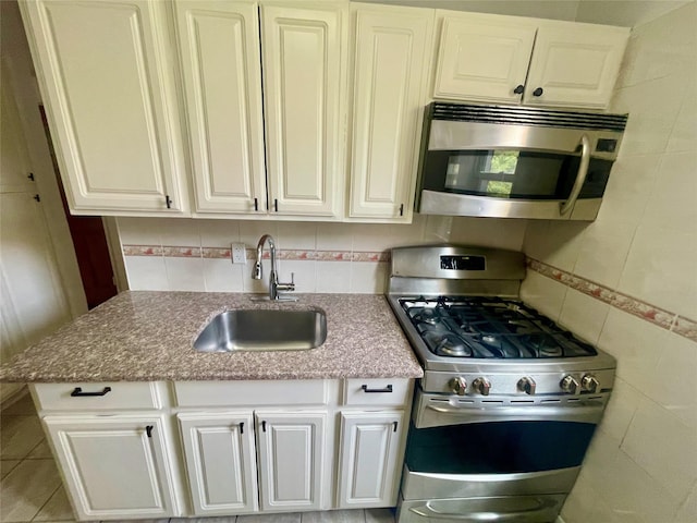 14340 41st Ave Unit 2G, Flushing, NY 11355 - kitchen featuring appliances with stainless steel finishes, a sink, white cabinetry, and tile walls