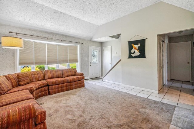 315 Fern Pl, Bethpage, NY 11714 - carpeted living room with vaulted ceiling, tile patterned flooring, baseboards, a textured ceiling, and a baseboard heating unit