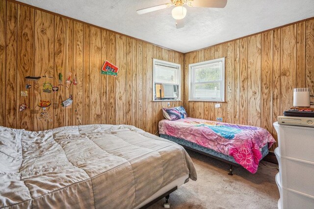 315 Fern Pl, Bethpage, NY 11714 - carpeted bedroom featuring wood walls, a textured ceiling, and a ceiling fan
