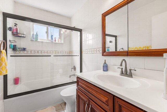 2 Cascade Ter Unit 1D, Yonkers, NY 10703 - bathroom with toilet, vanity, tile walls, shower / bath combination with glass door, and backsplash