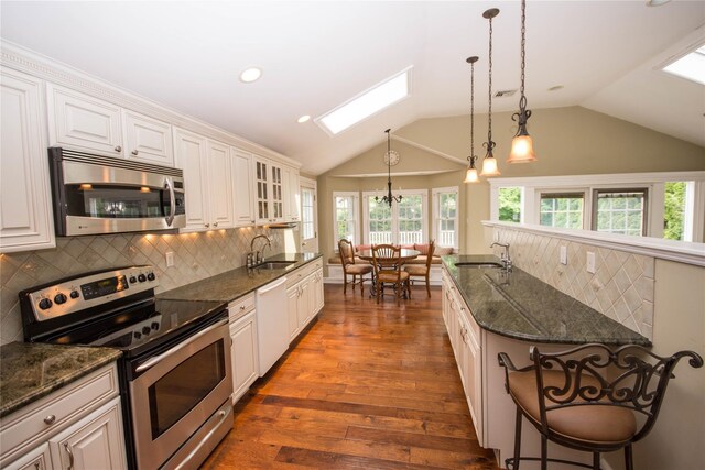51 Regina Dr, Sayville, NY 11782 - kitchen with stainless steel appliances, a sink, a skylight, decorative backsplash, and lofted ceiling