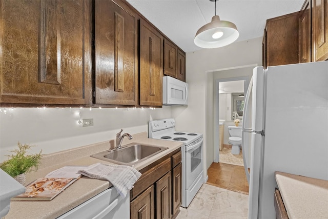 160 Academy St Unit 5C, Poughkeepsie, NY 12601 - kitchen featuring white appliances, a sink, dark brown cabinets, decorative light fixtures, and light countertops