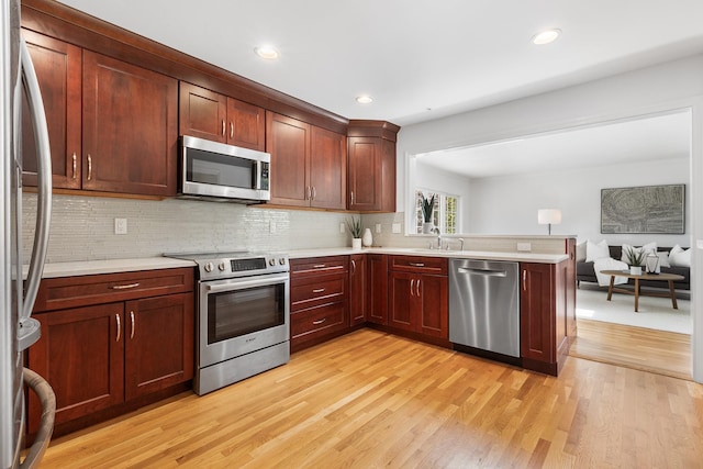 18 Halsey Pl, Valhalla, NY 10595 - kitchen with appliances with stainless steel finishes, light wood-style flooring, a sink, a peninsula, and open floor plan