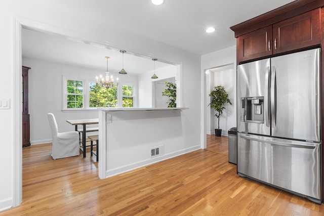 18 Halsey Pl, Valhalla, NY 10595 - kitchen with stainless steel fridge, light wood finished floors, a breakfast bar, a chandelier, and recessed lighting