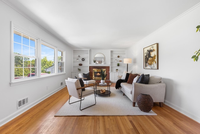 18 Halsey Pl, Valhalla, NY 10595 - living area featuring wood finished floors, a glass covered fireplace, baseboards, built in features, and crown molding