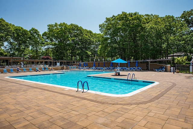 119 Exmore Ct Unit A, Ridge, NY 11961 - community pool featuring a patio area and view of scattered trees