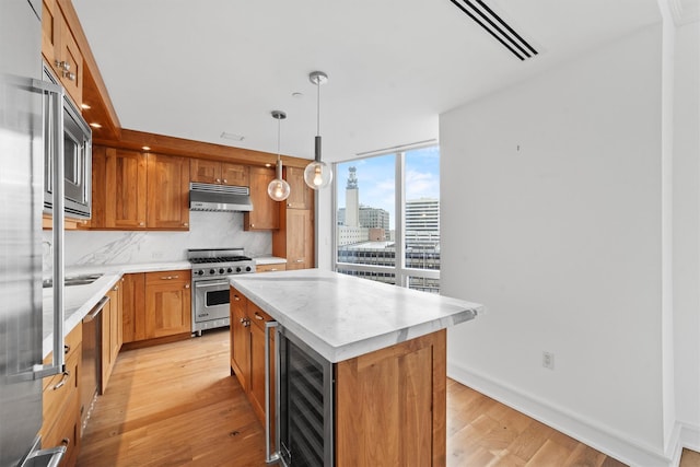 5 Renaissance Sq Unit 10G, White Plains, NY 10601 - kitchen with high end appliances, wine cooler, light wood-style floors, light countertops, and a kitchen island