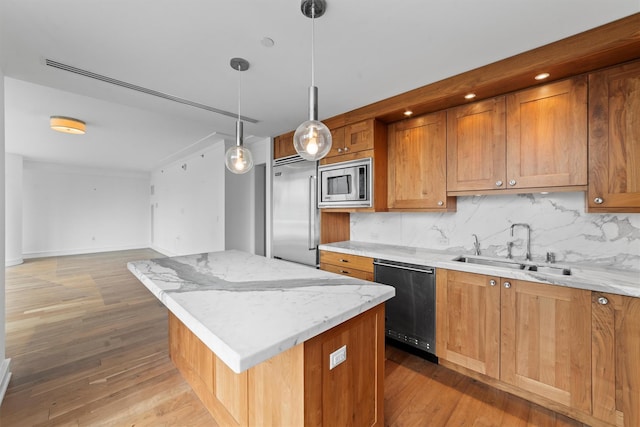 5 Renaissance Sq Unit 10G, White Plains, NY 10601 - kitchen with built in appliances, a sink, a center island, light wood-style flooring, and tasteful backsplash