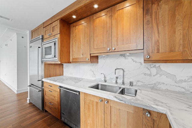 5 Renaissance Sq Unit 10G, White Plains, NY 10601 - kitchen with built in appliances, a sink, tasteful backsplash, dark wood-style flooring, and light stone counters