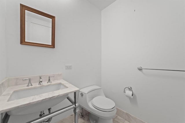 5 Renaissance Sq Unit 10G, White Plains, NY 10601 - half bathroom featuring toilet, a sink, and baseboards
