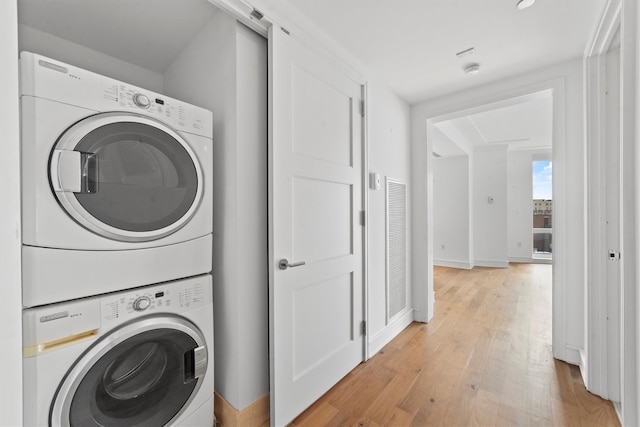 5 Renaissance Sq Unit 10G, White Plains, NY 10601 - laundry room featuring stacked washer / dryer, light wood-type flooring, and baseboards