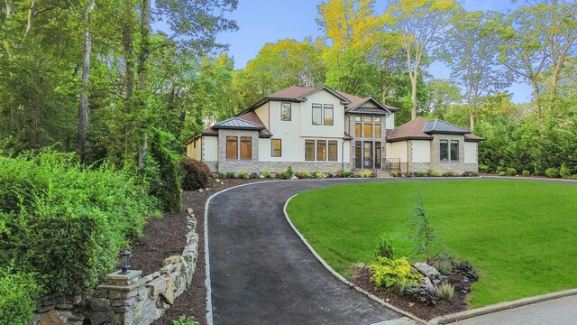 21 Arista Dr, Dix Hills, NY 11746 - view of front facade featuring stone siding, stucco siding, a standing seam roof, a front lawn, and a metal roof