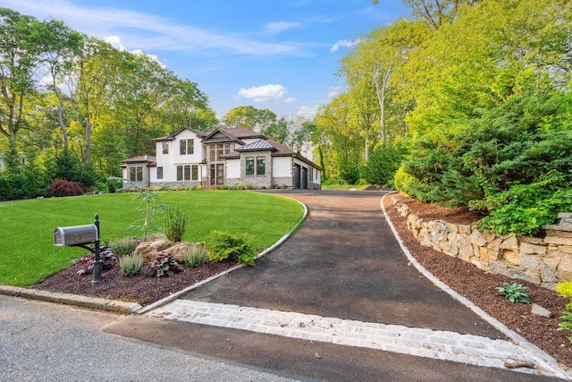 21 Arista Dr, Dix Hills, NY 11746 - view of front of property with a front yard, asphalt driveway, a garage, and stucco siding