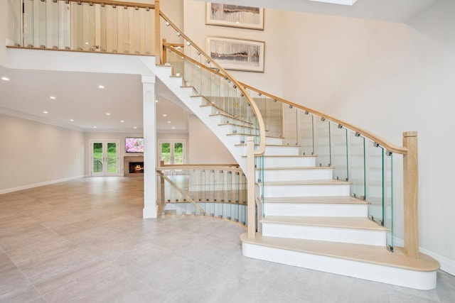 21 Arista Dr, Dix Hills, NY 11746 - staircase with a lit fireplace, a towering ceiling, recessed lighting, and ornamental molding