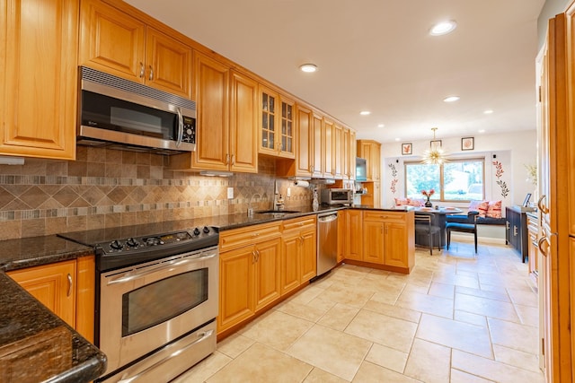 10 Hidden Harbor Dr Unit 10, Babylon, NY 11702 - kitchen featuring stainless steel appliances, dark stone countertops, backsplash, glass insert cabinets, and recessed lighting