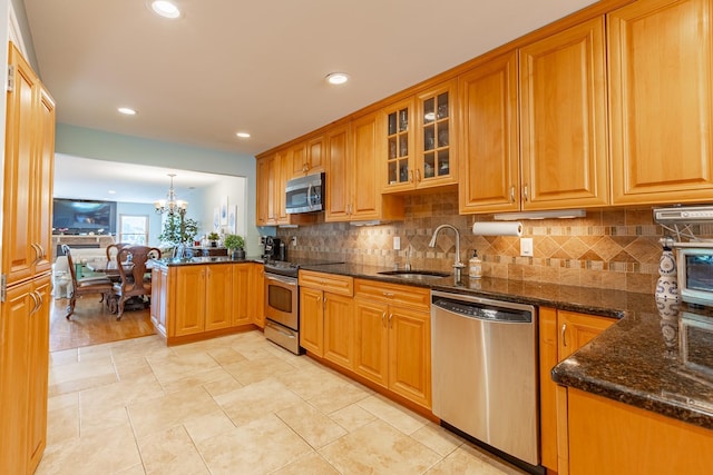 10 Hidden Harbor Dr Unit 10, Babylon, NY 11702 - kitchen featuring stainless steel appliances, a sink, a peninsula, a chandelier, and dark stone counters