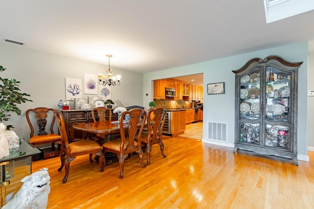 10 Hidden Harbor Dr Unit 10, Babylon, NY 11702 - dining space with a chandelier, light wood-style floors, and a skylight
