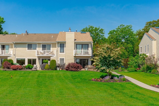 10 Hidden Harbor Dr Unit 10, Babylon, NY 11702 - rear view of house featuring a chimney, a lawn, and a balcony
