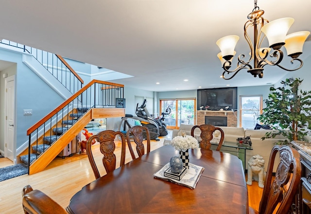 10 Hidden Harbor Dr Unit 10, Babylon, NY 11702 - dining space featuring a fireplace, wood finished floors, stairs, a chandelier, and recessed lighting