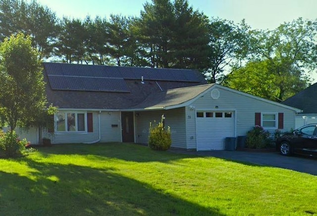 75 Split Cedar Dr, Islandia, NY 11749 - view of front facade featuring an attached garage, a front lawn, driveway, roof mounted solar panels, and roof with shingles