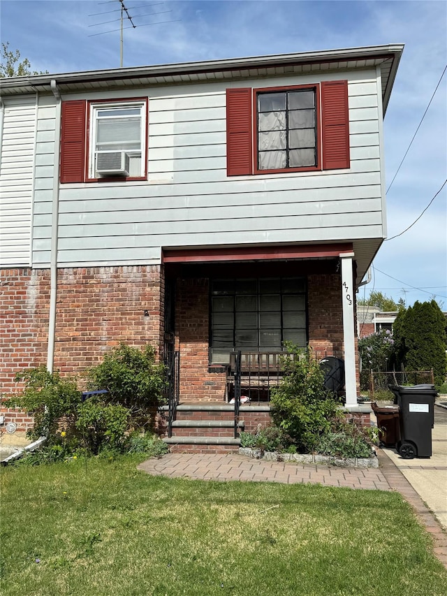 47-03 212th St, Bayside, NY 11361 - view of front of house featuring brick siding, a front lawn, and covered porch