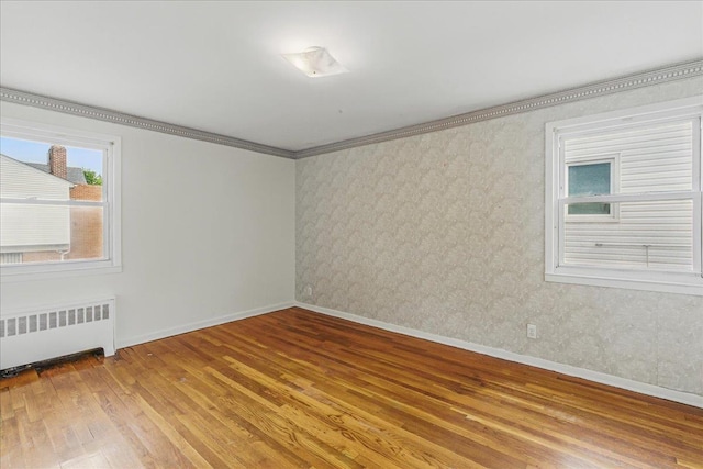 47-03 212th St, Bayside, NY 11361 - empty room featuring radiator, hardwood / wood-style flooring, wallpapered walls, and ornamental molding