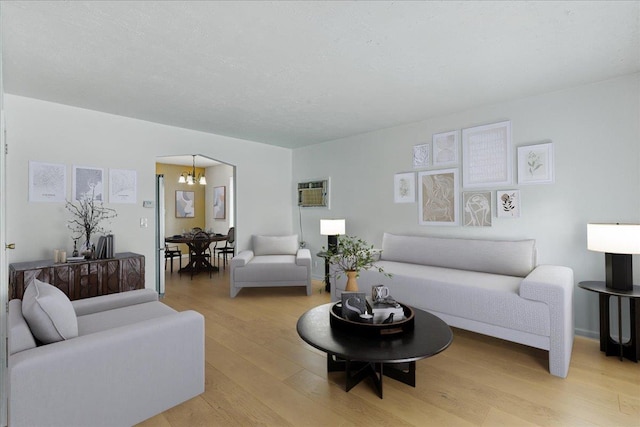 47-03 212th St, Bayside, NY 11361 - living room featuring a chandelier, light wood-style floors, and a wall mounted AC