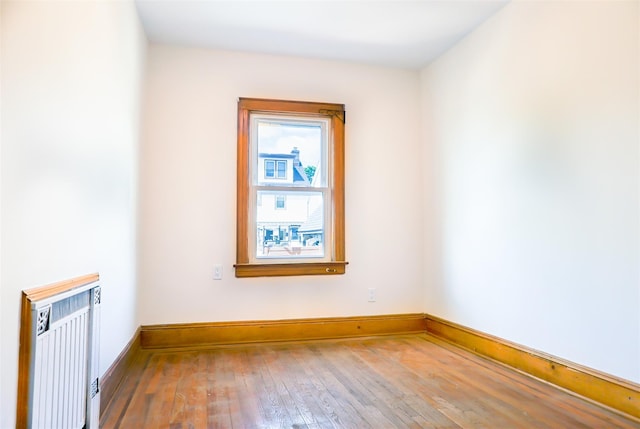 5428 65th Pl, Maspeth, NY 11378 - empty room with radiator heating unit, hardwood / wood-style flooring, and baseboards