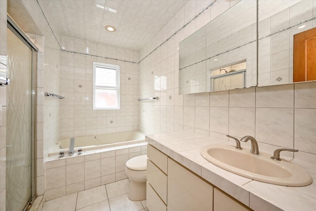 5428 65th Pl, Maspeth, NY 11378 - bathroom featuring tile walls, a stall shower, tiled bath, vanity, and tile patterned floors