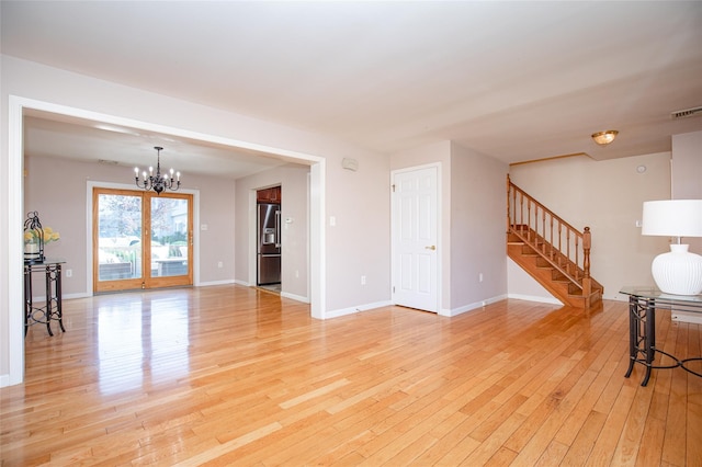 48 Zugibe Ct, West Haverstraw, NY 10993 - unfurnished living room with a chandelier, light wood-style floors, stairway, and baseboards