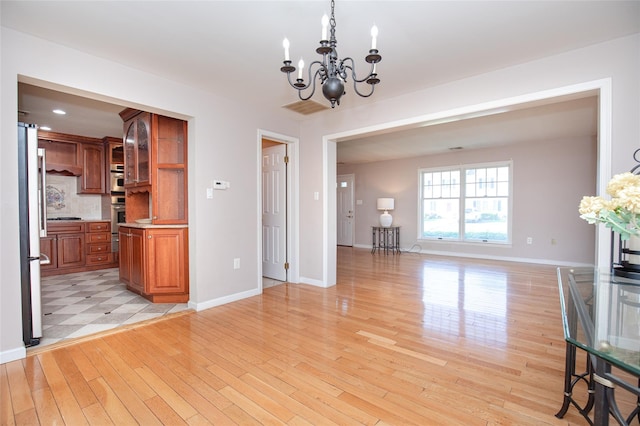 48 Zugibe Ct, West Haverstraw, NY 10993 - unfurnished living room with a chandelier, light wood-type flooring, baseboards, and recessed lighting