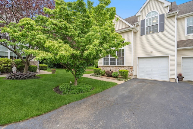 7 Yosemite Cir, Bohemia, NY 11716 - view of front of house featuring a front yard, a garage, asphalt driveway, a shingled roof, and stone siding