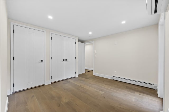 2118 45th Ave Unit 1And 2, Long Island City, NY 11101 - unfurnished bedroom featuring a baseboard heating unit, hardwood / wood-style flooring, multiple closets, baseboards, and recessed lighting