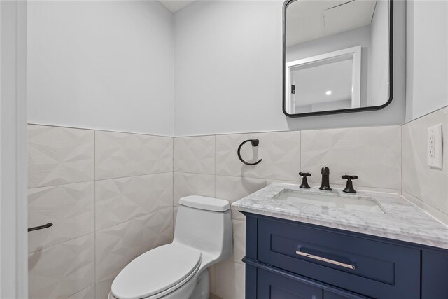 2118 45th Ave Unit 1And 2, Long Island City, NY 11101 - half bathroom featuring tile walls, vanity, toilet, and a wainscoted wall