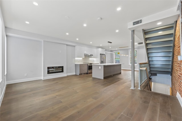 2118 45th Ave Unit 1And 2, Long Island City, NY 11101 - unfurnished living room with baseboards, recessed lighting, wood finished floors, and a glass covered fireplace