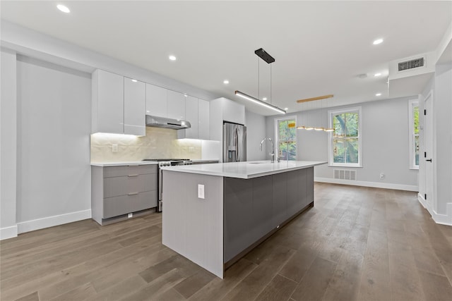 2118 45th Ave Unit 1And 2, Long Island City, NY 11101 - kitchen with modern cabinets, stainless steel appliances, under cabinet range hood, light countertops, and recessed lighting