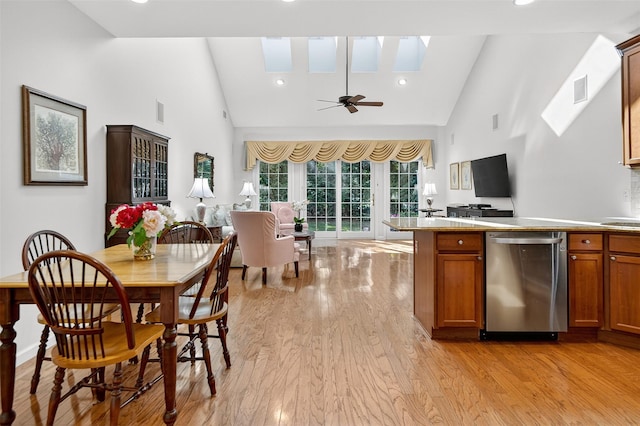 12 Miro Pl Unit 31, Port Washington, NY 11050 - kitchen featuring dishwasher, a skylight, light wood-style floors, brown cabinetry, and high vaulted ceiling