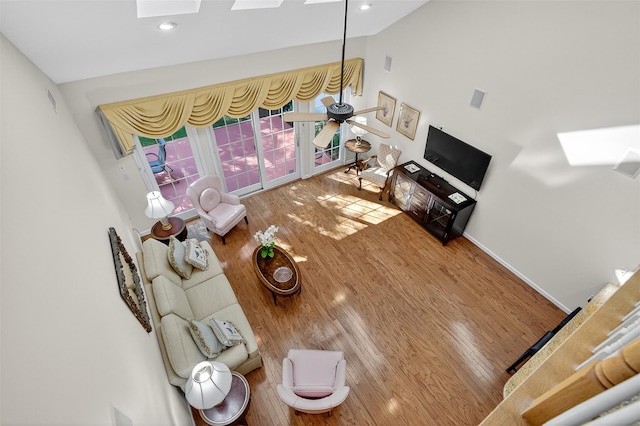 12 Miro Pl Unit 31, Port Washington, NY 11050 - living area featuring a skylight, wood finished floors, and vaulted ceiling