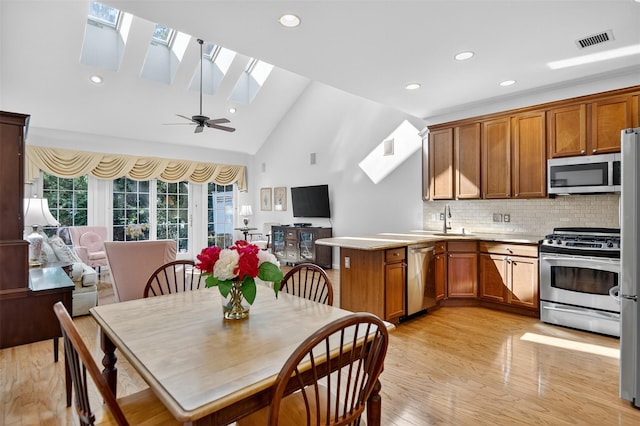 12 Miro Pl Unit 31, Port Washington, NY 11050 - kitchen featuring stainless steel appliances, a skylight, a peninsula, recessed lighting, and brown cabinets