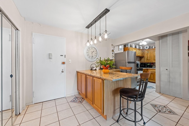 68-20 Selfridge St Unit 2F, Forest Hills, NY 11375 - kitchen with freestanding refrigerator, a peninsula, light tile patterned floors, and a kitchen breakfast bar