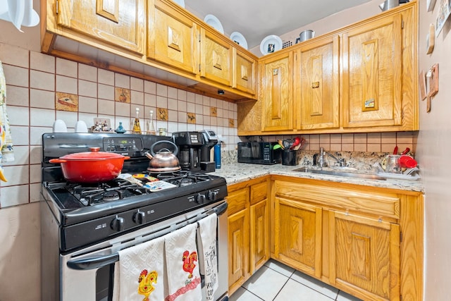 68-20 Selfridge St Unit 2F, Forest Hills, NY 11375 - kitchen with stainless steel range with gas stovetop, a sink, light tile patterned floors, tasteful backsplash, and light stone counters
