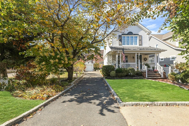95-01 72nd Ave, Forest Hills, NY 11375 - view of front of property with covered porch, a front lawn, an outbuilding, and a detached garage