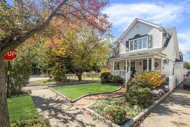 95-01 72nd Ave, Forest Hills, NY 11375 - view of front of home featuring a porch, a front yard, driveway, and a shingled roof