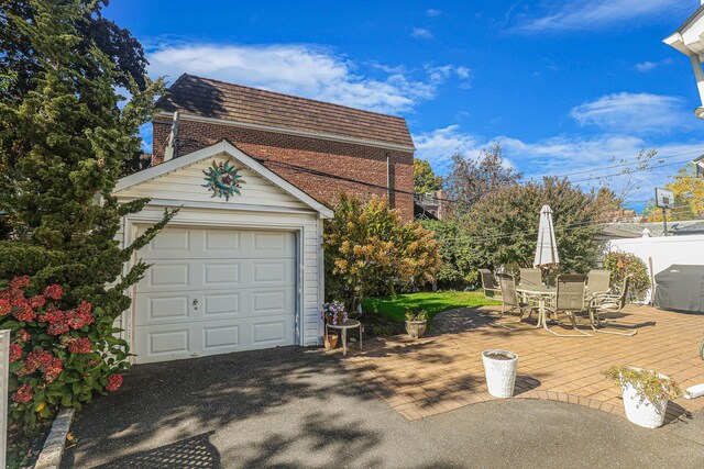 95-01 72nd Ave, Forest Hills, NY 11375 - view of side of home with brick siding, mansard roof, outdoor dining space, a garage, and an outdoor structure