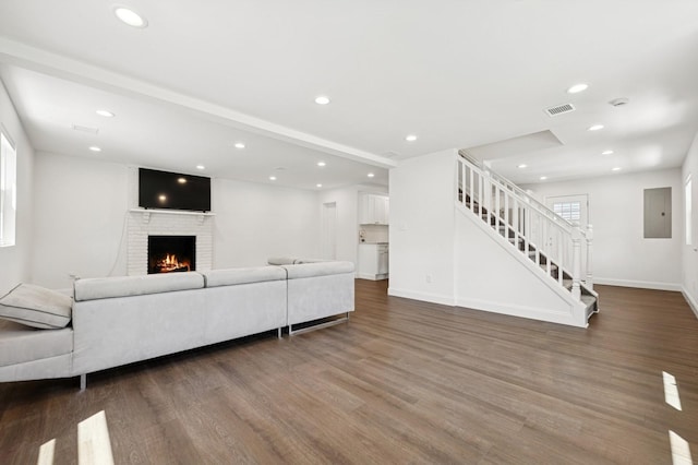 42 Chernucha Ave, Merrick, NY 11566 - living room with wood finished floors, stairway, a brick fireplace, recessed lighting, and electric panel