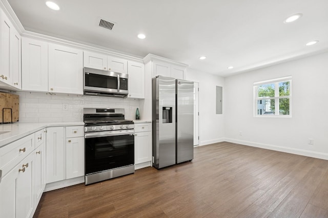 42 Chernucha Ave, Merrick, NY 11566 - kitchen with appliances with stainless steel finishes, electric panel, tasteful backsplash, white cabinets, and dark wood-type flooring